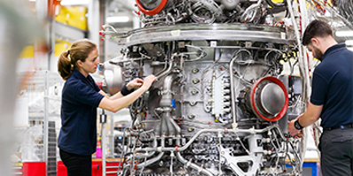 Photo of two engineers working on a large engine
