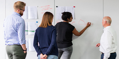 engineers at a whiteboard higher education recognition